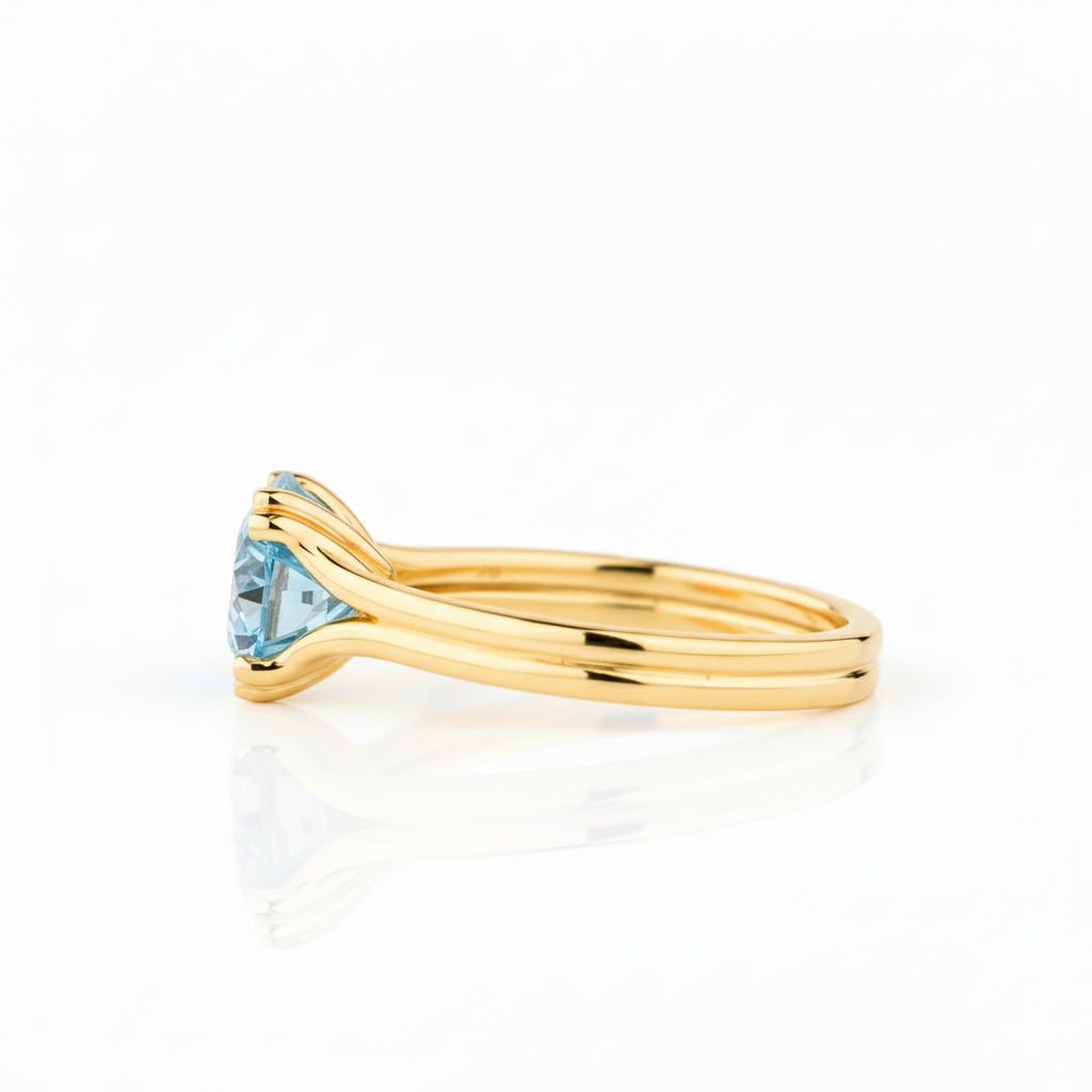 Gold ring with a blue gemstone on a white background