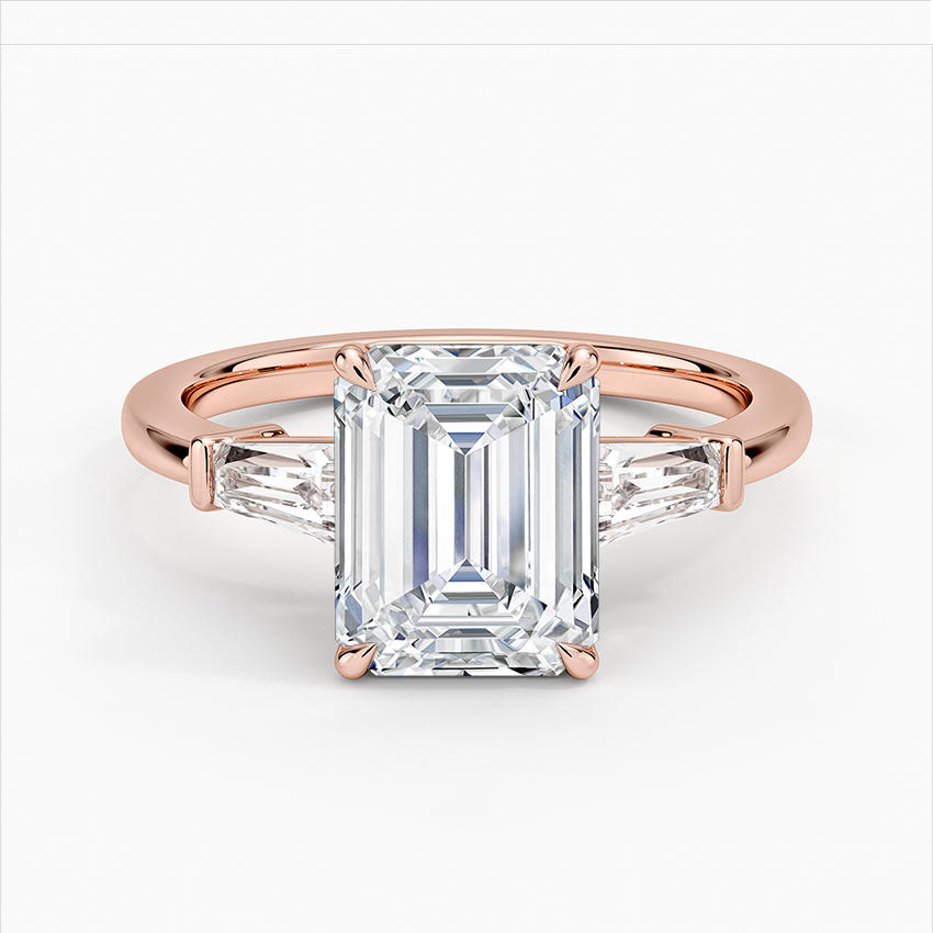 Rose gold ring with emerald-cut diamond on a white background