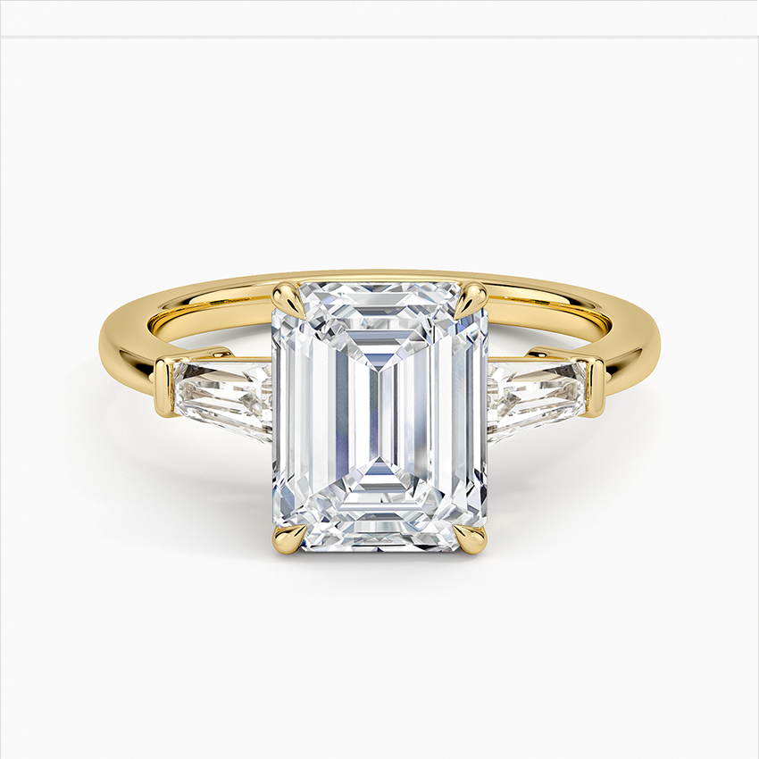 Gold ring with a large emerald-cut diamond on a white background