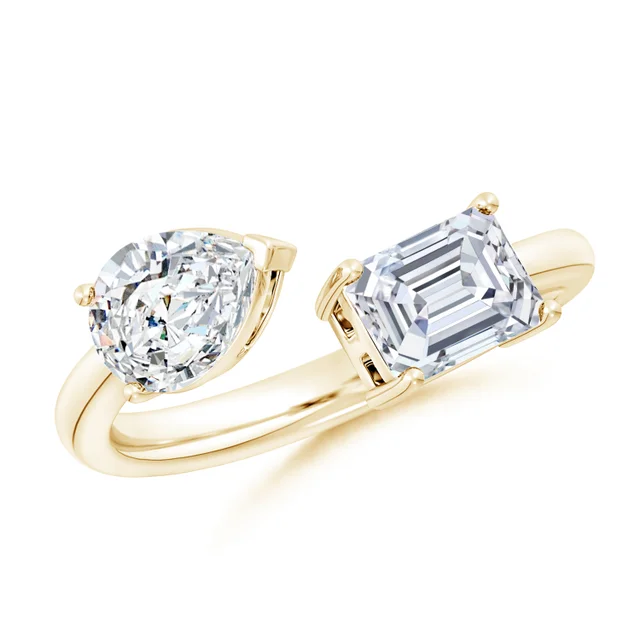 Gold ring with heart-shaped and emerald-cut diamonds on a white background