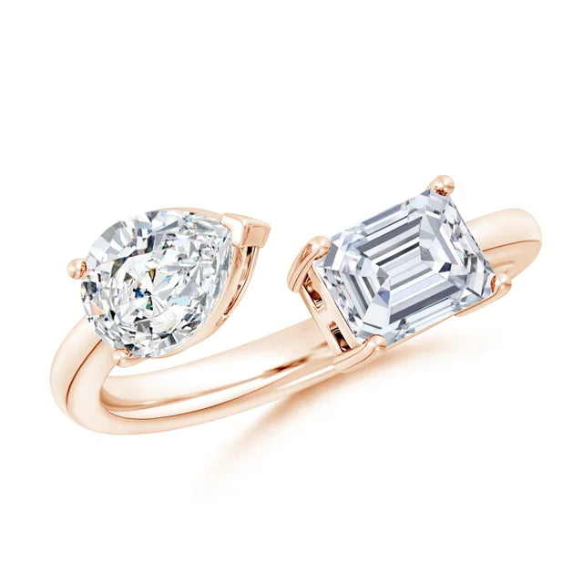 Rose gold ring with heart-shaped and emerald-cut diamonds on a white background