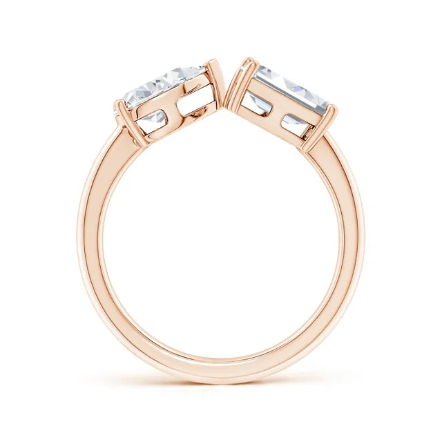 Rose gold ring with two prominent gemstones on a white background