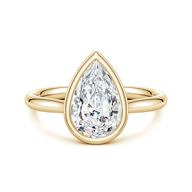 Gold ring with a pear-shaped diamond on a white background