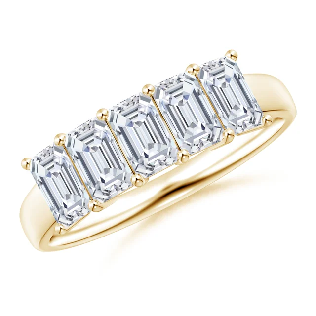 Gold ring with emerald-cut diamonds on a white background