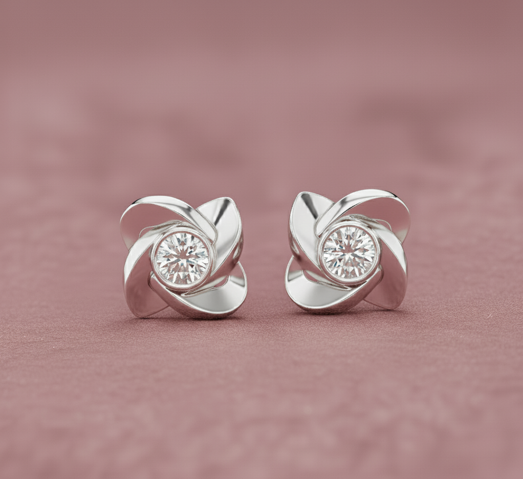 Silver earrings with diamond-like centers on a pink background