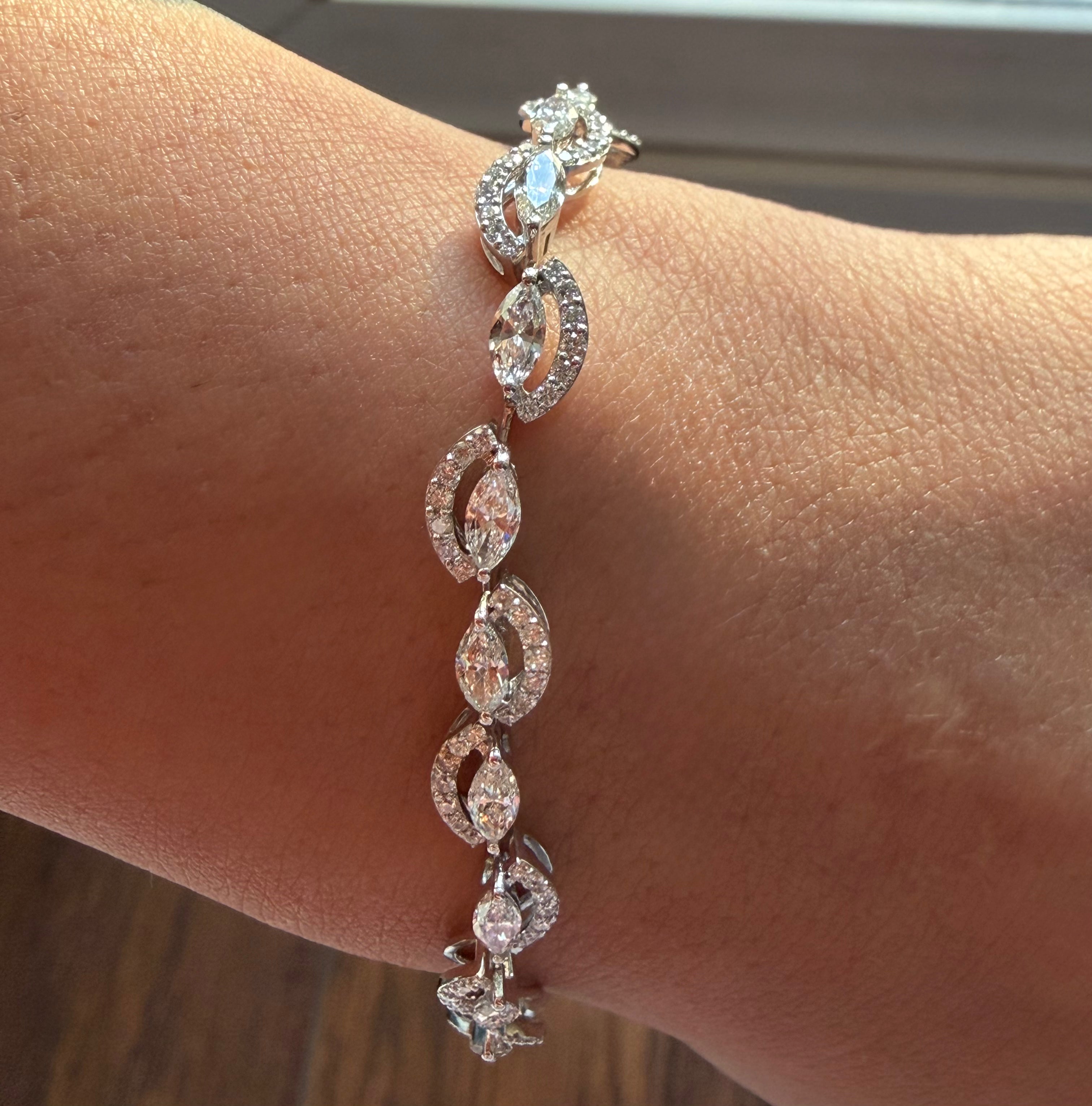 Silver bracelet with clear stones on a wrist against a neutral background