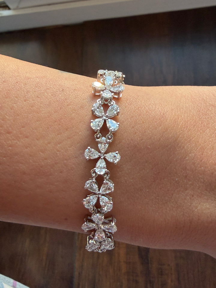 Silver bracelet with clear stones on a wrist against a blurred background
