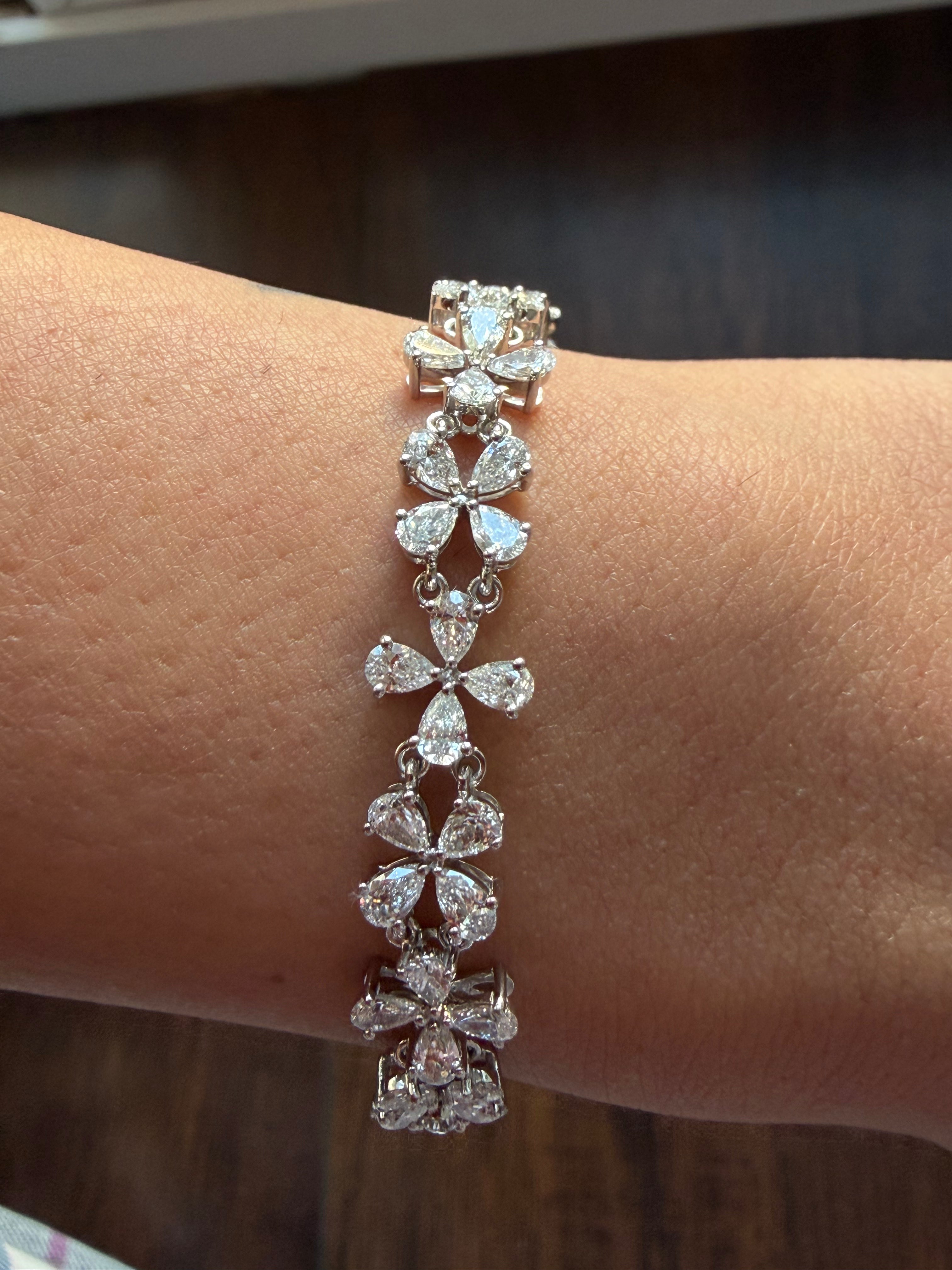 Silver bracelet with diamond accents on a wrist against a blurred background
