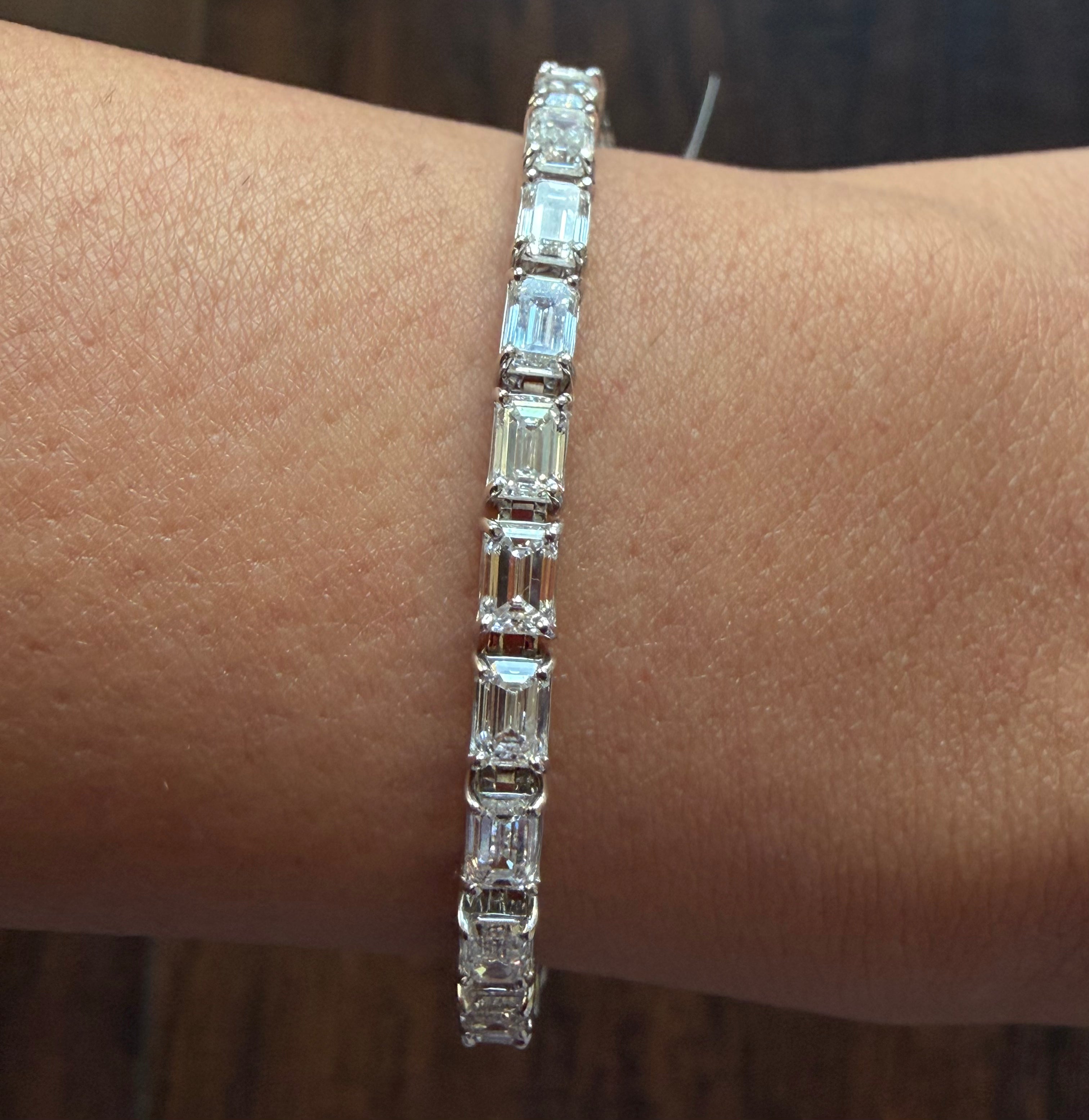 Diamond bracelet on a wrist against a neutral background