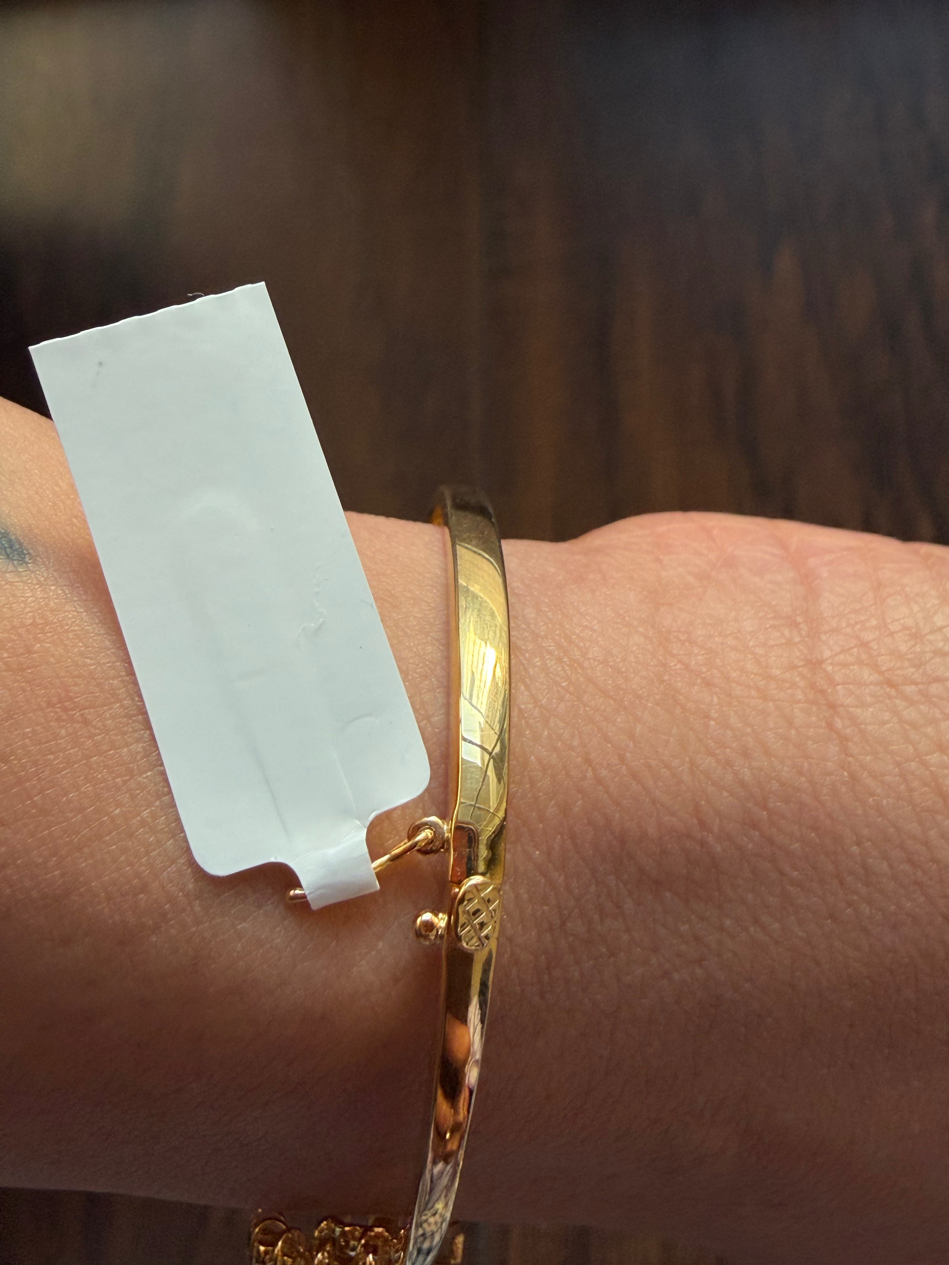 Gold bracelet on a wrist with a blurred background