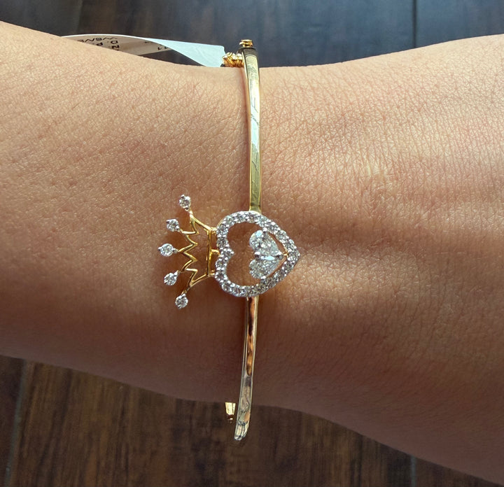 Gold bracelet with decorative elements on a wrist against a wooden background