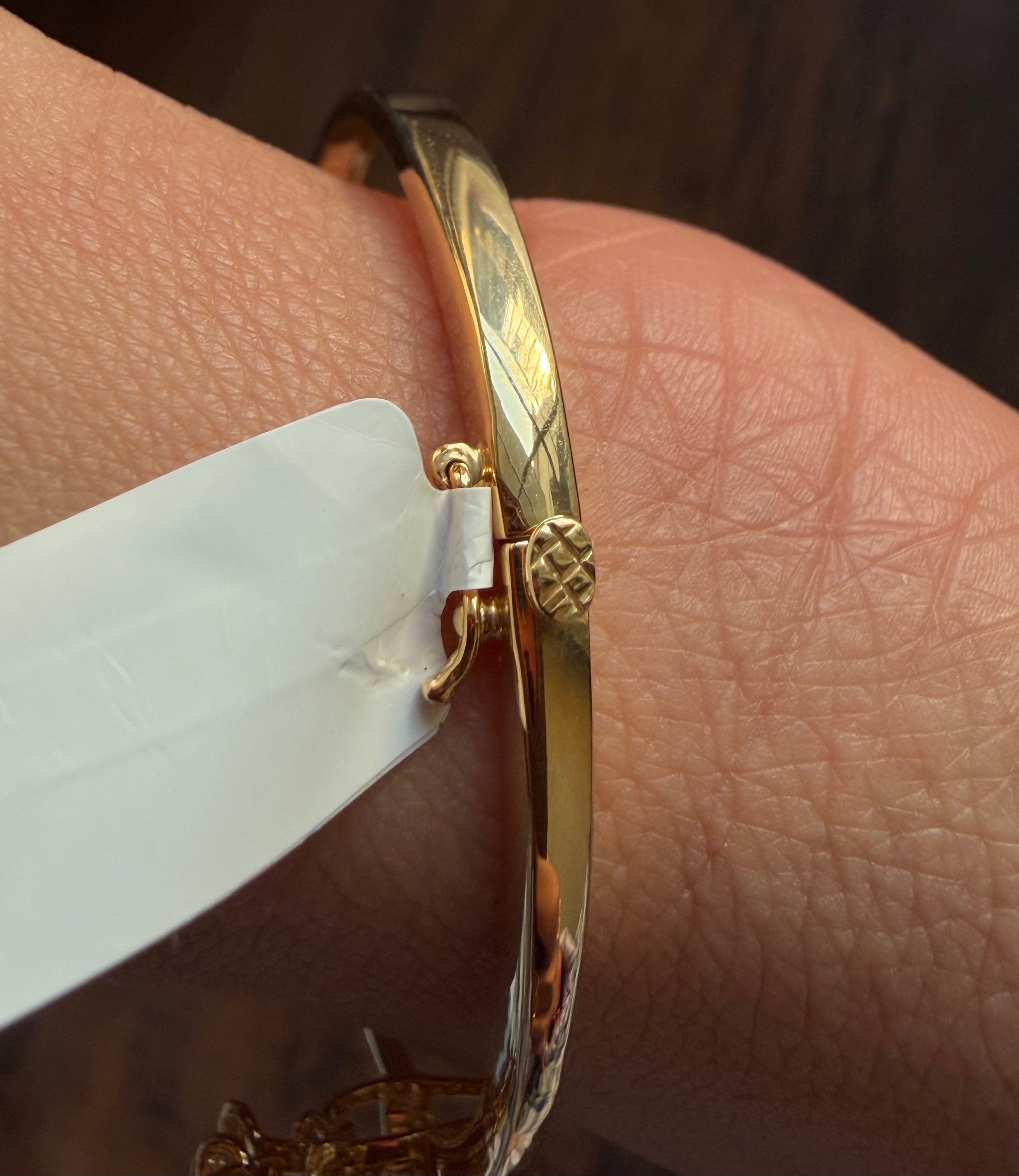 Gold bracelet on a wrist with a blurred background