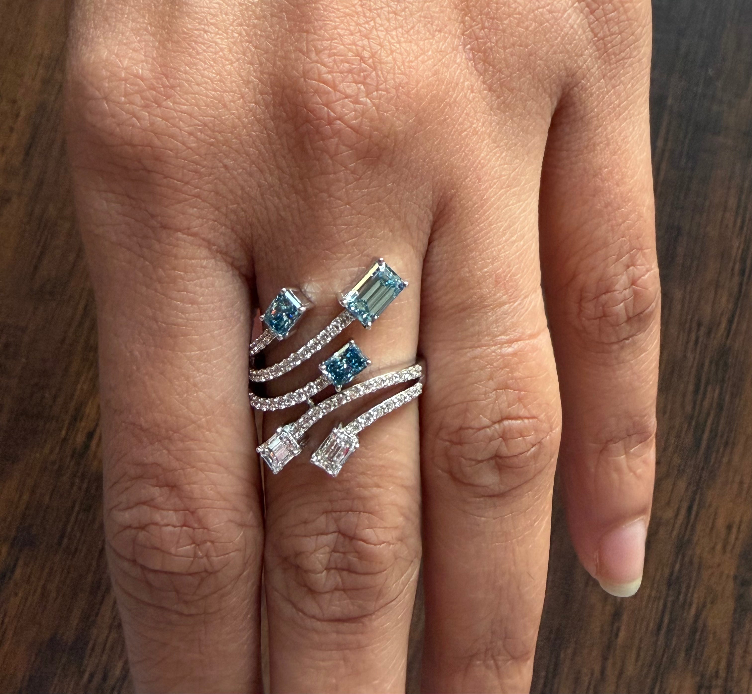 Close-up of a hand wearing a ring with blue gemstones on a wooden surface