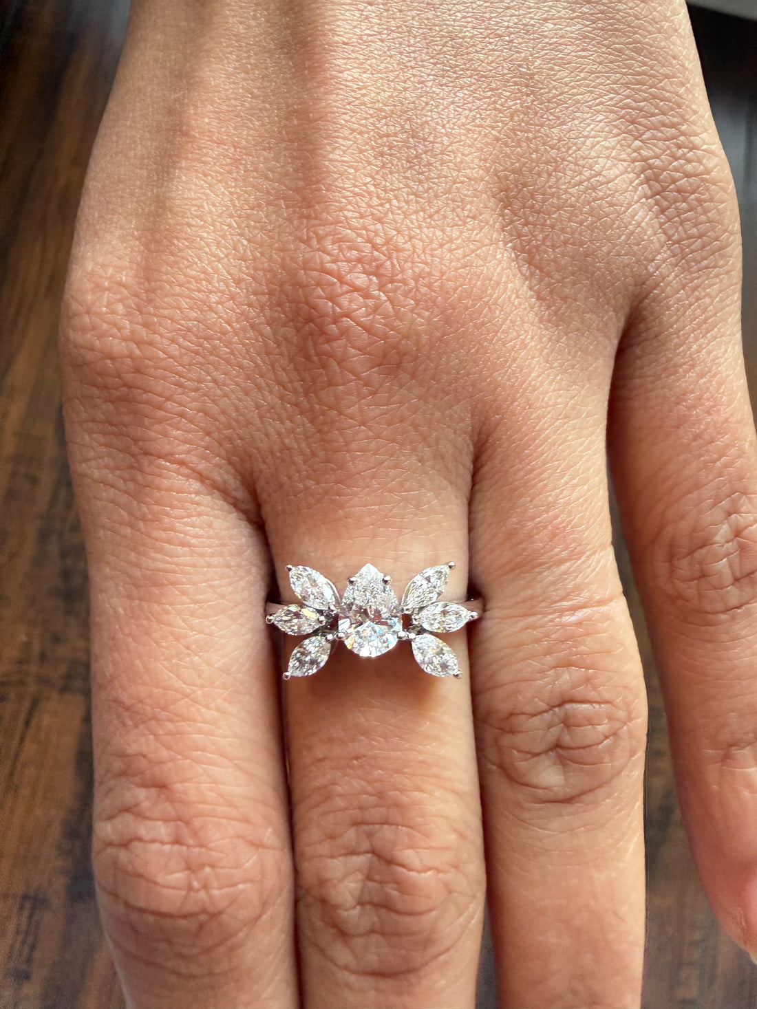 Diamond ring on a finger with a wooden surface background