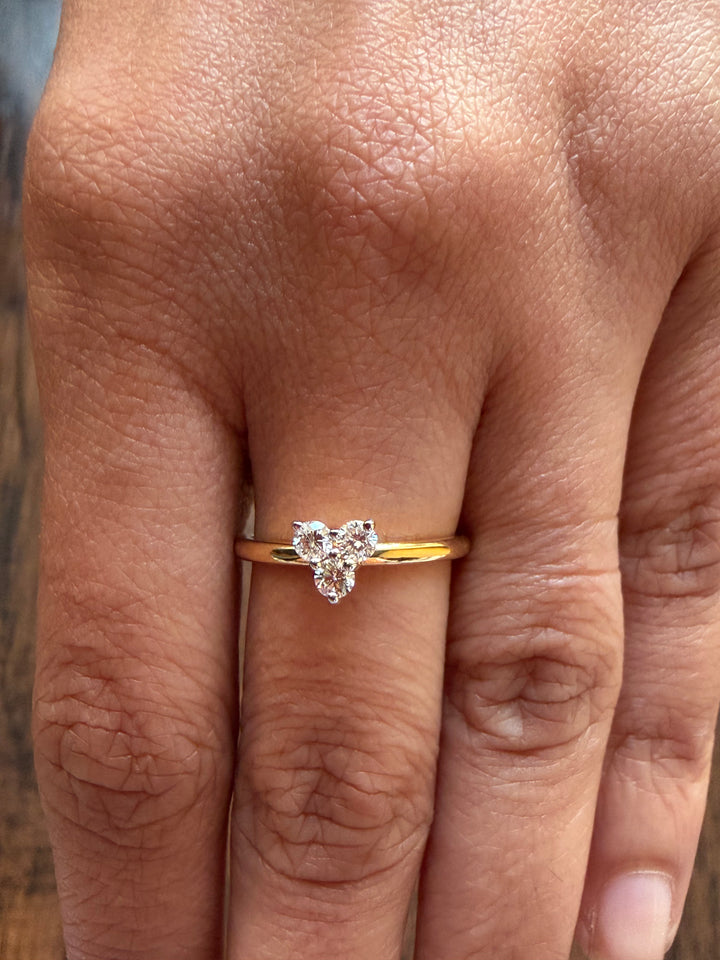 Gold ring with a heart-shaped diamond on a person's finger