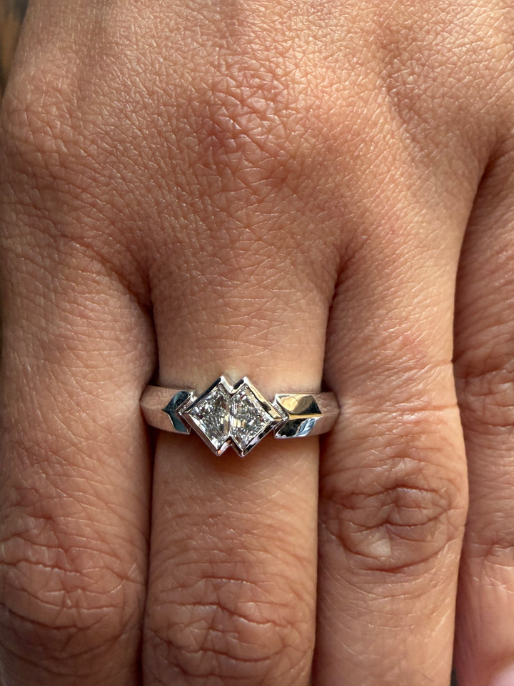 Close-up of a hand wearing a diamond ring with a silver band.