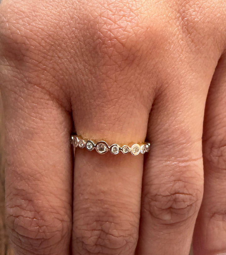 Close-up of a hand wearing a diamond ring on a light background