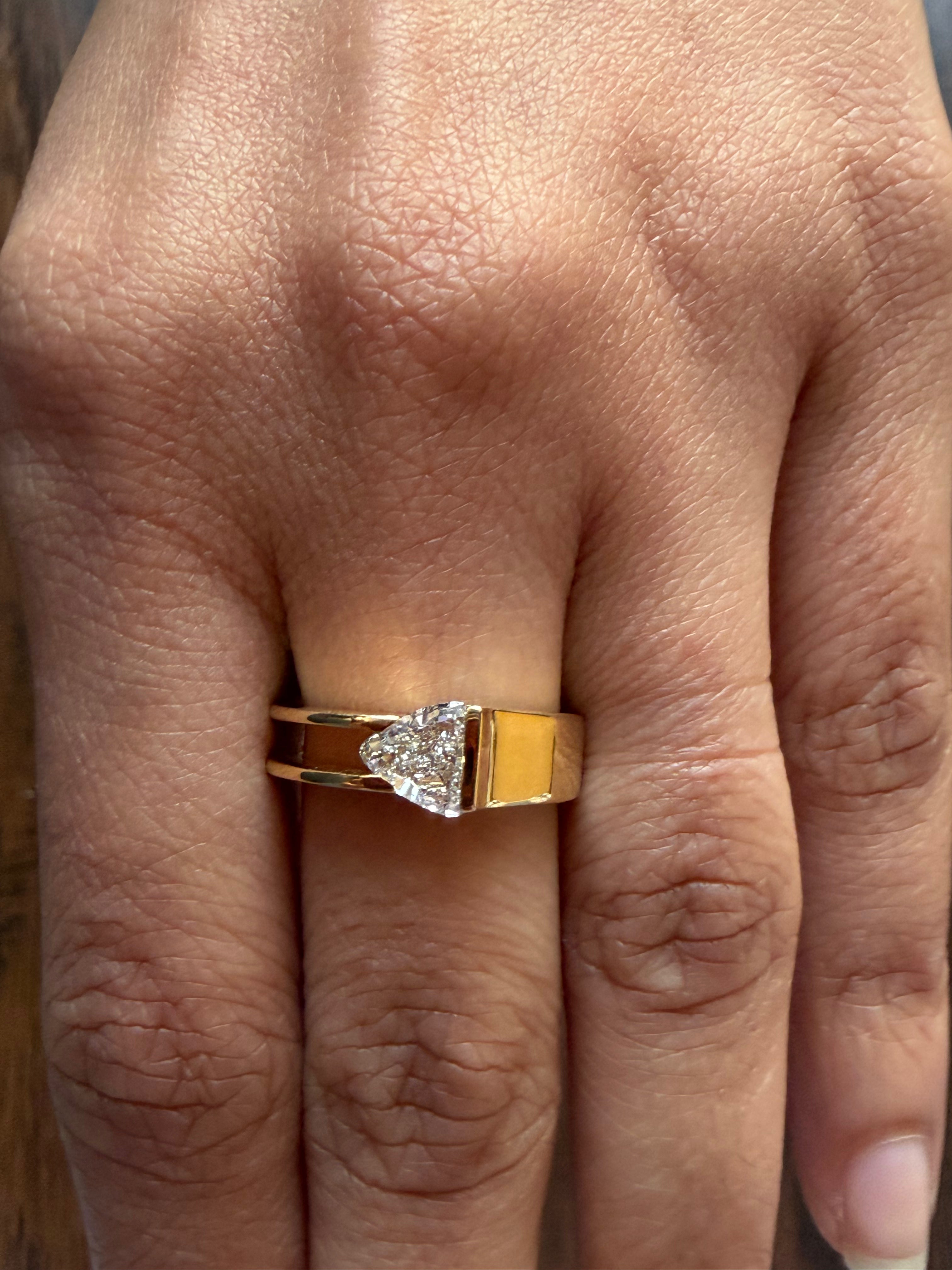 Gold ring with a heart-shaped diamond on a person's finger