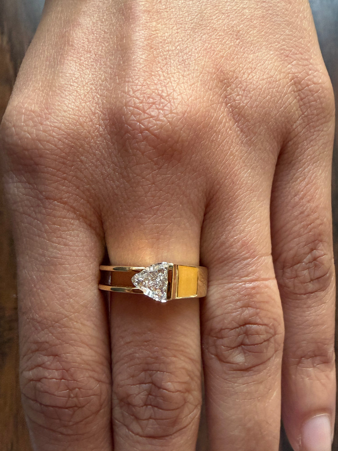 Gold ring with a diamond on a person's finger