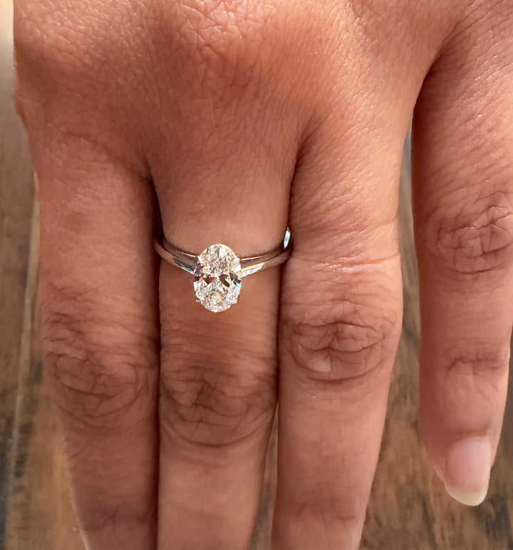 Diamond ring on a finger with a blurred background