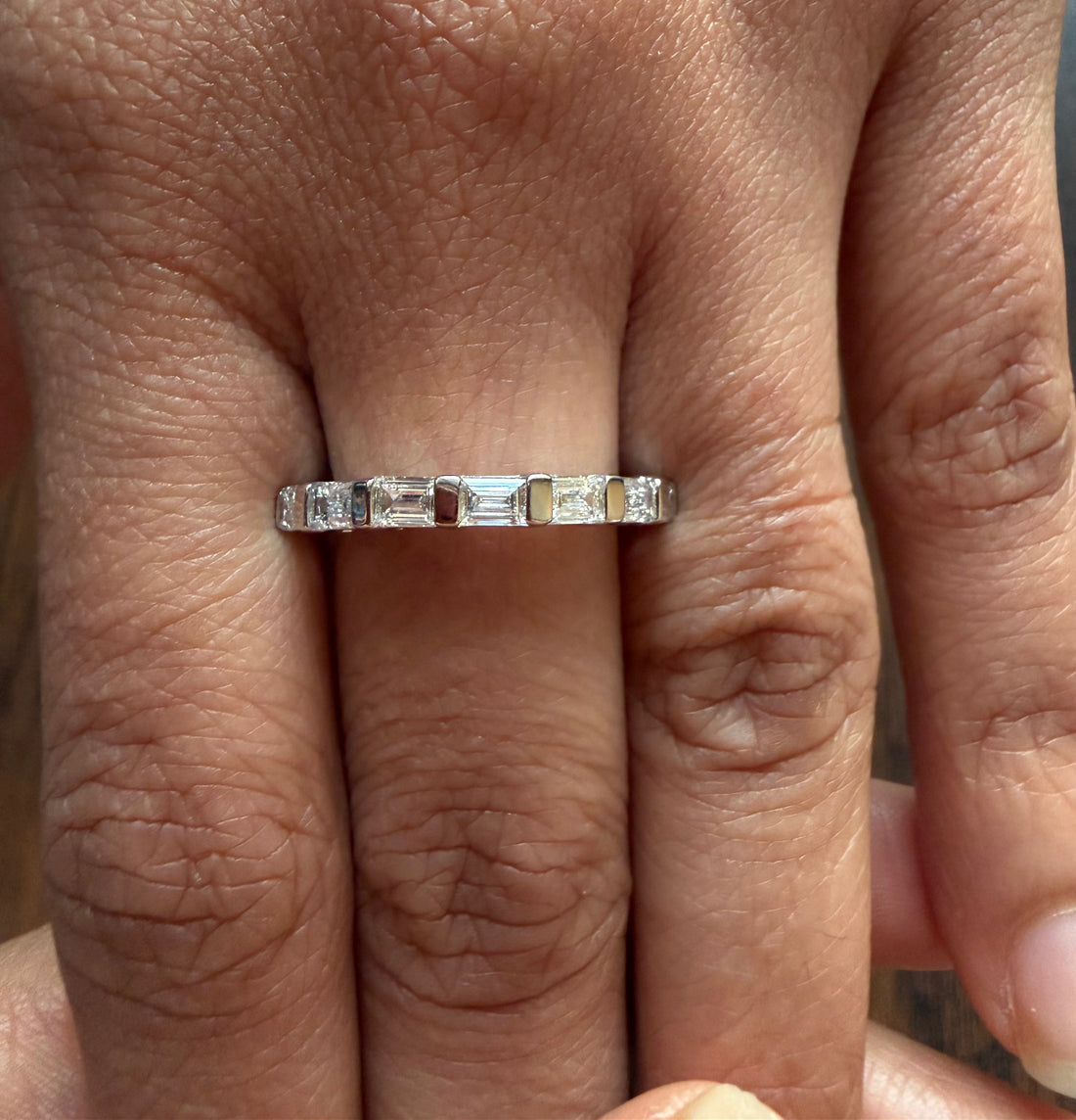 Silver ring with gemstones on a person's finger